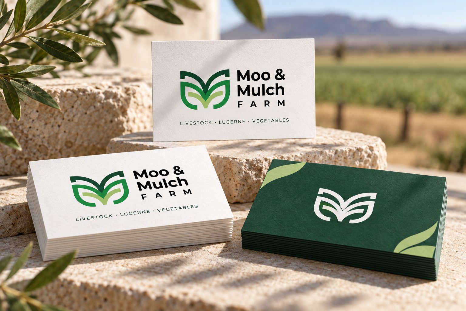 Moo & Mulch Farm white and forest-green business cards on stone display blocks